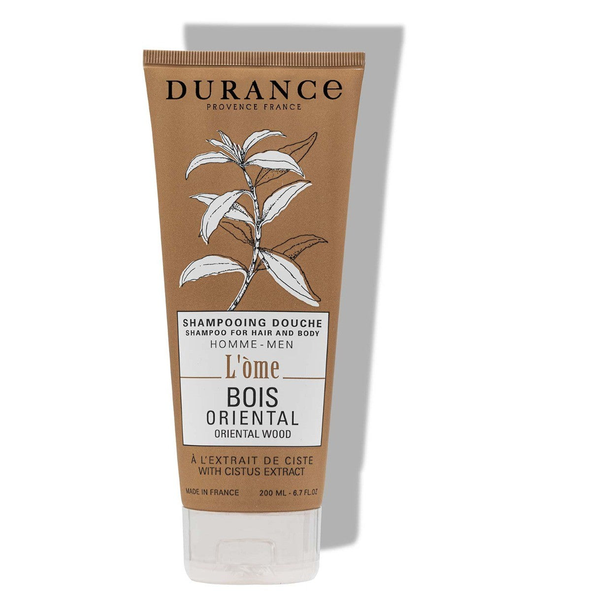 A tube of Durance Oriental Wood  shampoo with the label 'L'Ome' indicating it is an aromatic shampoo with cistus extract. The packaging is primarily brown with white and black text and graphics.