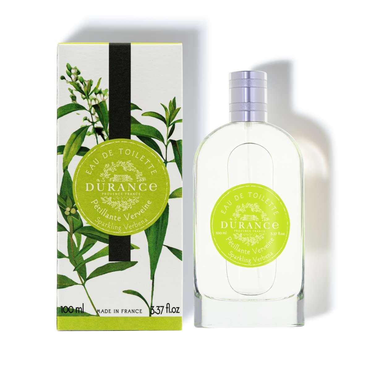 A bottle of Durance sparkling verbena eau de toilette perfume next to its packaging box, both featuring a green label with images of verbena leaves 